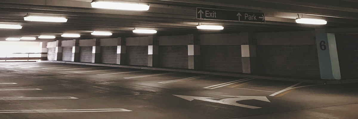 An empty level of a multi-storey car park with bright lighting and clear signage
